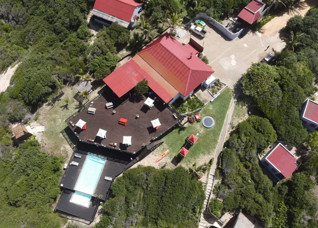 Sunset Beach Resort from above, red roofs, pool and dune bush at Chidenguele